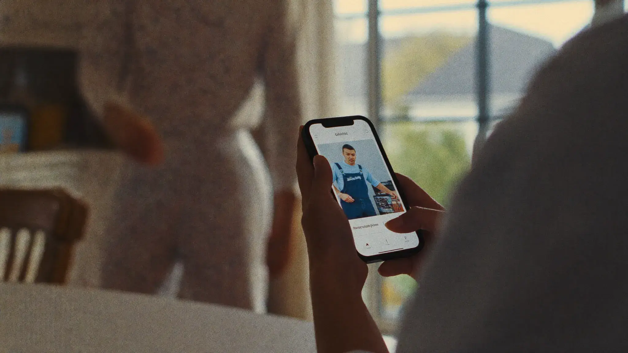 A homeowner searching for a local tradesperson on their phone